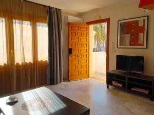 ein Wohnzimmer mit einem Flachbild-TV und einer Tür in der Unterkunft Apartamento Oasis in Playas de Vera