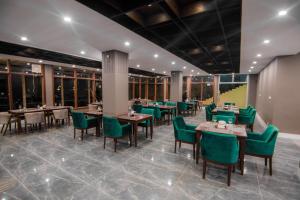 una sala da pranzo con tavoli e sedie verdi di Tibet Hotel a Skardu