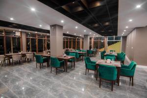 锡卡都Tibet Hotel的有桌子和绿色椅子的餐厅