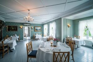 a dining room with tables and chairs and a chandelier at Gloppen Hotell - by Classic Norway Hotels in Sandane
