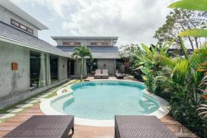 a swimming pool in the backyard of a house at Kano Canggu Loft in Canggu