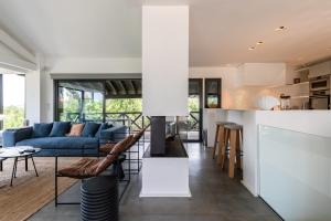 uma sala de estar com um sofá azul e uma cozinha em MILADY KEYWEEK Villa with Pool Ocean Views in Biarritz em Biarritz