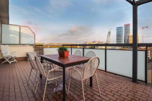 a table and chairs on a balcony with a view at UCA14 Luxury large apartment with private terrace in Citylife in Milan