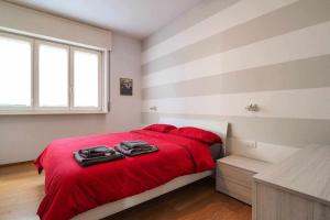 a bedroom with a red bed with red pillows at UCA14 Luxury large apartment with private terrace in Citylife in Milan