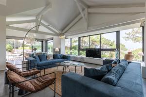 a living room with blue furniture and large windows at MILADY KEYWEEK Villa with Pool Ocean Views in Biarritz in Biarritz