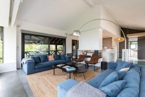 uma sala de estar com sofás azuis e uma mesa em MILADY KEYWEEK Villa with Pool Ocean Views in Biarritz em Biarritz