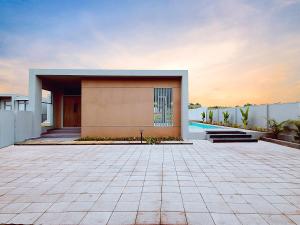 VAMA Retreats في بانغالور: منزل به فناء بلاط أمام مبنى