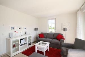 a living room with a couch and a tv at Villa Gesine App 01 - Strandkorb in Nienhagen +11 photos