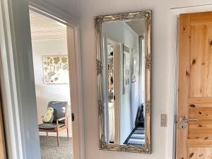 ein Spiegel, der in einem Zimmer an der Wand hängt in der Unterkunft Værelse Midtfyn Heden in Ringe