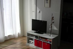 una TV a schermo piatto posizionata sopra un centro di intrattenimento di Haus Bucheneck App 07 a Graal-Müritz Altre 10 foto