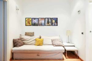 a couch in a living room with paintings on the wall at SV18C Charming modern flat S Ambrogio in Milan