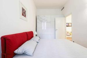 a red couch in a white room with a bed at SV18C Charming modern flat S Ambrogio in Milan