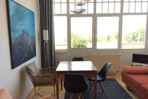 sala de estar con mesa, sillas y sofá en Haus Undine App 01 Seeblick, en Warnemünde