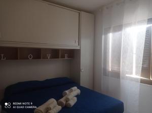 1 dormitorio con 1 cama con toallas enrolladas en Tortolì-Porto Frailis-Arbatax, en Àrbatax