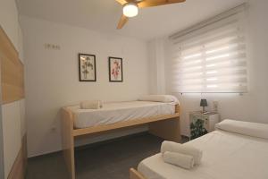 - une chambre avec 2 lits et un ventilateur de plafond dans l'établissement 069 - Panorama 001 - comfortHOLIDAYS, à Santa Pola