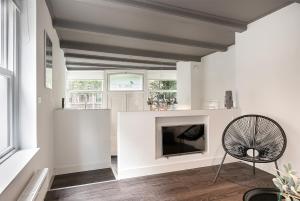 a living room with a fireplace and a chair at Apartment Eewal 68 in Leeuwarden