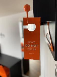 a paper bag hanging from a door with a do not disturb sign at easyHotel Lisbon in Lisbon