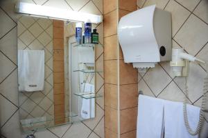 a shower in a hotel room with a soap dispenser and towels at 7even weddings & events in Štip