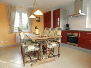 a kitchen with a wooden table and chairs at Gîte La Grenouillère in Esquéhéries