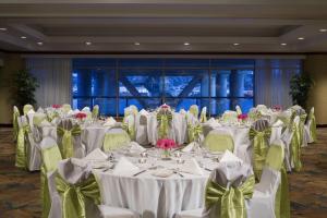 un salón de banquetes con mesas blancas y sillas con flores en Inn At The Quay en New Westminster
