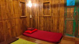 a red bed in a room with a wooden wall at Bungalow Mat Hj Limah in Alor Setar +75 photos
