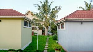 a yard between two houses with palm trees at Samanene Hotel in Mwanza