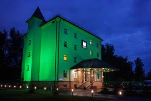 秋明的住宿－布拉格公園酒店，一座晚上有绿灯的建筑