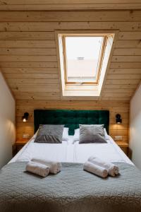 ein Schlafzimmer mit einem großen Bett mit zwei Handtüchern darauf in der Unterkunft Czorsztyn View Apartamenty in Czorsztyn
