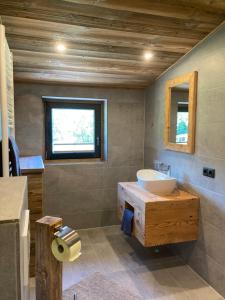 a bathroom with a sink and a tub and a window at Öfnerhof in Leutasch