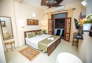 1 dormitorio con 1 cama, mesa y sillas en Fort Thari Inn, en Galle