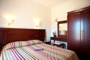a bedroom with a bed and a dresser and a mirror at Lito Beach Hotel in Gerani Chanion