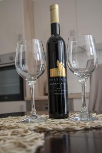 een fles wijn en twee wijnglazen op een tafel bij Viollet in Omiš