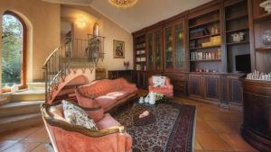 sala de estar con sofá y sillas en una biblioteca en Villa Sylva 6&2, Emma Villas, en Frattocchie