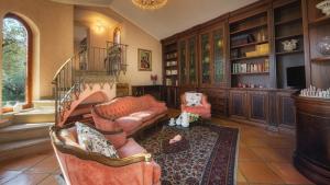salon z kanapą i krzesłami w bibliotece w obiekcie Villa Sylva 6&2, Emma Villas w mieście Frattocchie
