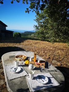a picnic table with a plate of food on it at Le Cabanon de Gourdon bergerie rénové en pierre vue mer in Gourdon