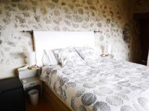 a bedroom with a large white bed with a window at Le Cabanon de Gourdon bergerie rénové en pierre vue mer in Gourdon