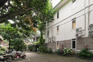 un groupe de motos garées à côté d'un bâtiment dans l'établissement Urbanview Hotel Minongga Pondok Labu by RedDoorz, à Jakarta