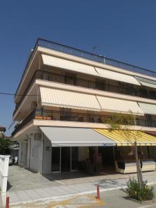 a building with a white awning in front of it at Emmanuel Apartments in Paralia Katerinis