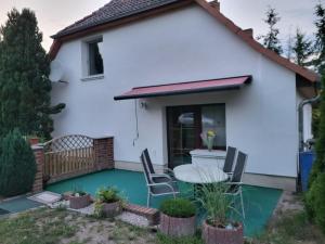 una casa bianca con tavolo e sedie di Land,Wald und Wiese a Jürgenstorf