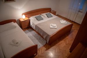 een slaapkamer met 2 bedden en handdoeken bij Viollet in Omiš