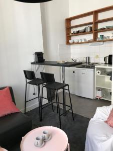 a living room with a table and chairs and a kitchen at studio de 30 m2 dans le triangle d'or de Bordeaux in Bordeaux +7 photos