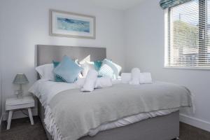 Un dormitorio con una cama con almohadas azules y blancas. en 6 Challacombe - Luxury Apartment at Byron Woolacombe, only 4 minute walk to Woolacombe Beach!, en Woolacombe 33 fotos más