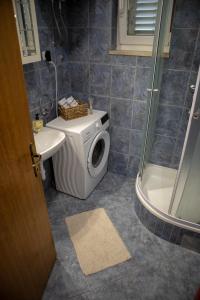 een badkamer met een wasmachine en een wastafel bij Viollet in Omiš