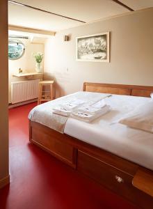 a bedroom with a large bed with a wooden frame at Péniche Daphné's in Auvers-sur-Oise