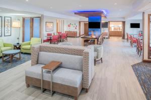 a living room with a couch and tables and chairs at Holiday Inn Express Hotel & Suites Bismarck, an IHG Hotel in Bismarck