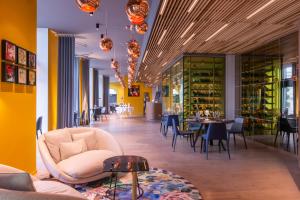 a restaurant with yellow walls and tables and chairs at Golden Tulip Saint Malo– Le Grand Bé in Saint Malo