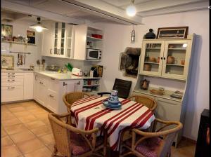 a kitchen with a table and chairs and a kitchen with white cabinets at Pexe na mar in Lastres