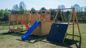 a wooden playground with a blue slide and a play structure at Sominkowe Wzgórze in Sominy
