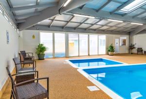 uma sala de piscina com cadeiras e uma piscina em Finest Retreats - Serendipity Lodge em Torpoint