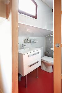 a bathroom with a white sink and a toilet at Péniche Daphné's in Auvers-sur-Oise